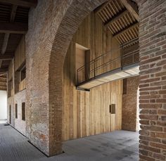 an old brick building with wooden walls and stairs leading up to the second floor area