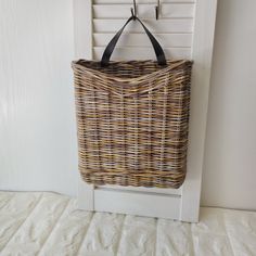 a wicker bag hanging on a white door