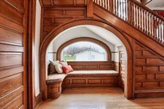 an arched entryway with wooden paneling and bench