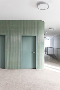 an empty room with green walls and doors