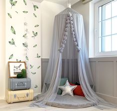 a canopy bed with pink and white flowers on the wall above it, along with other accessories