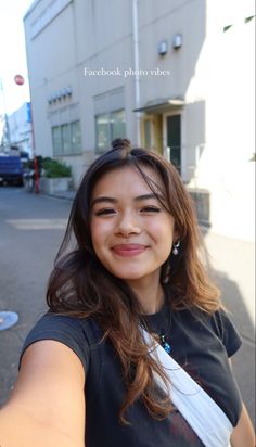 a woman is taking a selfie with her cell phone in front of a building