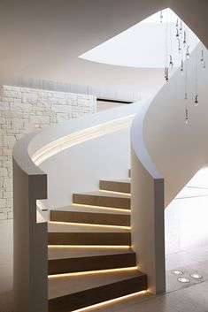 a white staircase with wooden steps and lights