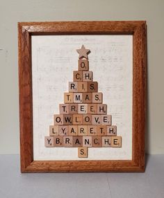 a wooden scrabble christmas tree in a frame