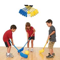 three children are playing with toys on the floor and one boy is holding a broom