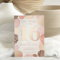 a pink and gold birthday party card with confetti on it next to a vase