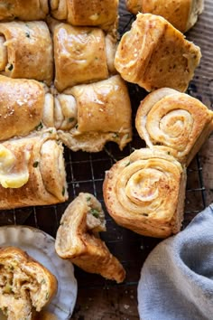 several pieces of bread sitting on top of a cooling rack next to plates with pastries