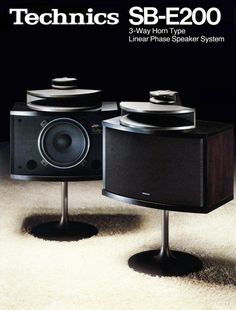 two speakers sitting on top of each other in front of a white carpeted floor