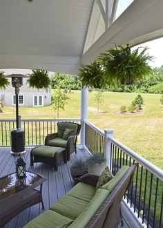 an outdoor living area with furniture on the deck and trees in the backgroud