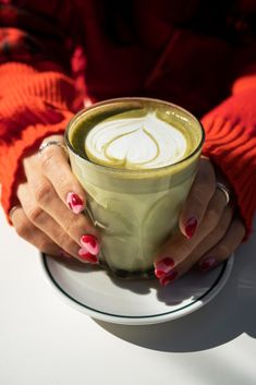 a woman's hands holding a cup of coffee