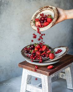 a person is sprinkling strawberries into a pie