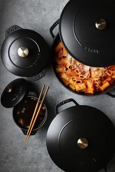 an overhead view of some pots and pans with food in them next to chopsticks