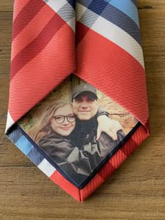 a red, blue and white neck tie with a photo on the bottom half of it