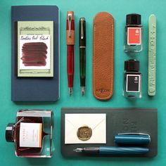 the contents of a fountain pen, ink roller, and other items laid out on a table