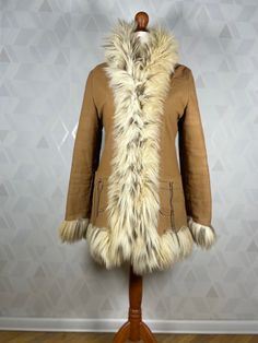 A beautiful coat made of fabric finished with fur imitating wild cat fur. Lovely pockets on the sides. The coat is in very good condition, no damage or unpleasant odors. Dimensions: sleeve from collar: 72 cm (measured without fur) sleeve from armpit: 40 cm (measured without fur) bust:2x45 cm in waist:2x 44 cm in the hips:2x 47 cm total length: 72 cm Our mannequin is size M. Brown Fur Coat With Faux Fur Trim, Brown Long Sleeve Fur Coat With Faux Fur Trim, Brown Faux Fur Outerwear With Pockets, Beige Hooded Fur Coat With Faux Fur Trim, Beige Faux Fur Coat For Cold Weather, Brown Faux Fur Long Coat, Bohemian Long Sleeve Fur Coat With Faux Fur Lining, Brown Fur Coat With Faux Fur Trim For Winter, Fall Fur Coat With Feather Trim For Cold Weather