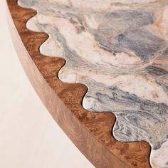 a close up view of a marble table top with wavy lines on the edge and wood