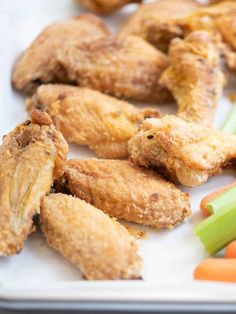 chicken wings, celery sticks and carrots on a tray with other foods