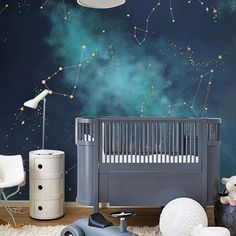 a baby's room with stars in the sky painted on the wall and a crib next to it