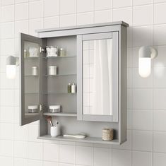 a bathroom medicine cabinet with its doors open and shelves on the wall next to it