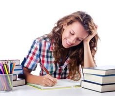 a woman sitting at a desk with books and pencils in front of her face