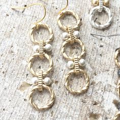 three pairs of earrings sitting on top of a table