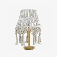 a white lamp with tassels on it