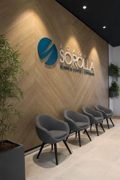 chairs are lined up in front of a wall with the logo sorolla on it