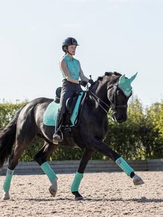 a woman riding on the back of a black horse