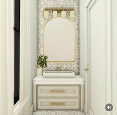 a white and gold bathroom with an oval mirror on the wall next to a dresser