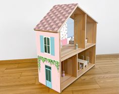 a wooden doll house sitting on top of a hard wood floor