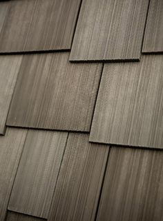 a close up view of the shingles on a house's roof, with dark wood