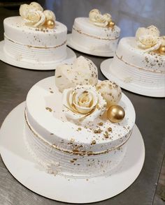 there are three white cakes with gold decorations on the top one is decorated with roses