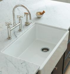 a white kitchen sink sitting under a faucet