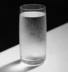 a glass filled with water sitting on top of a table