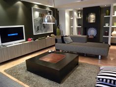 a living room filled with furniture and a flat screen tv on top of a wooden table