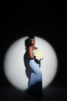 a woman in a long blue dress holding a bouquet