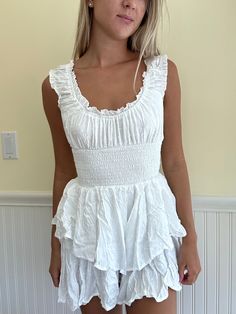 This white boho mini dress is perfect for any occasion! It features a flowy, feminine silhouette with shorts on the inside for added comfort and coverage. The dress is made from a lightweight, breathable fabric that is perfect for warm weather. It also features a tie waist that can be cinched to flatter your figure. This dress is perfect for a day at the beach, a casual picnic in the park, or even a night out on the town. It can be dressed up or down, depending on the occasion. Pair it with sand