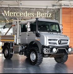 a mercedes benz truck parked in front of a mercedes benz sign