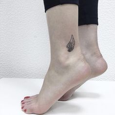 a woman's foot with a small wing tattoo on her left side calfocks