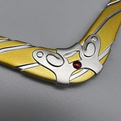 a yellow and silver object with a red eye