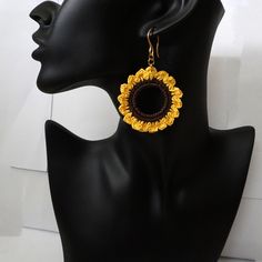 Dangling Crochet Sunflower Earrings Add a touch of sunshine to your look with these stunning dangling crochet sunflower earrings! Each earring is carefully handcrafted from high-quality cotton thread, shaped into a beautiful yellow sunflower. The earrings are large and striking, yet lightweight and comfortable to wear. The stainless steel earring hooks are available in two colors, gold and steel, so you can choose the perfect pair to complement your style. Whether you're dressing up for a special occasion or just running errands, these earrings are sure to turn heads. Features: Dangling earrings crocheted from cotton thread Shaped like yellow sunflowers Strikingly large earrings Stainless steel earring hooks (available in gold or steel) Lightweight and comfortable to wear Benefits: Stylish Summer Gift Jewelry With Sunflower Design, Bohemian Sunflower Design Flower Earrings As Gift, Bohemian Sunflower Earrings For Gift, Bohemian Sunflower Earrings As Gift, Bohemian Sunflower Design Earrings For Gift, Bohemian Gold Flower Earrings For Beach, Summer Gold Jewelry With Sunflower Design, Gold Jewelry With Sunflower Design For Summer, Bohemian Yellow Sunflower Earrings