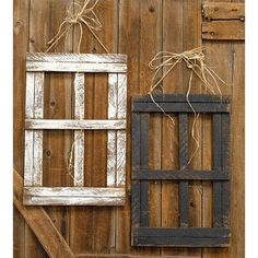 two old wooden windows tied with twine on the side of a barn wall, one is open and the other is closed