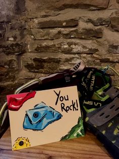 there is a card that says you rock next to some shoes on the table with a note