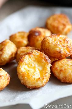 some fried food sitting on top of a piece of parchment paper with cheese toppings