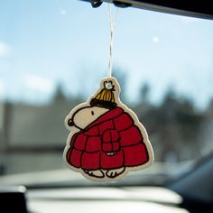 an ornament hanging from the dashboard of a car with a cartoon character on it