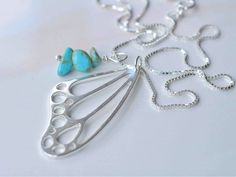 a silver necklace with two turquoise stones on it