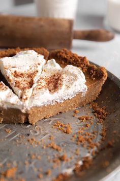 a piece of pie with whipped cream and cinnamon on top is sitting on a plate