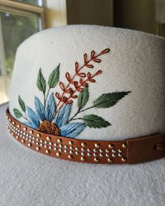 a white hat with blue flowers on it