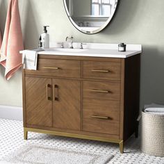 a bathroom with a sink, mirror and towels on the rack in front of it