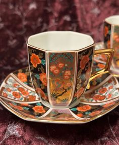 two cups and saucers with floral designs on them